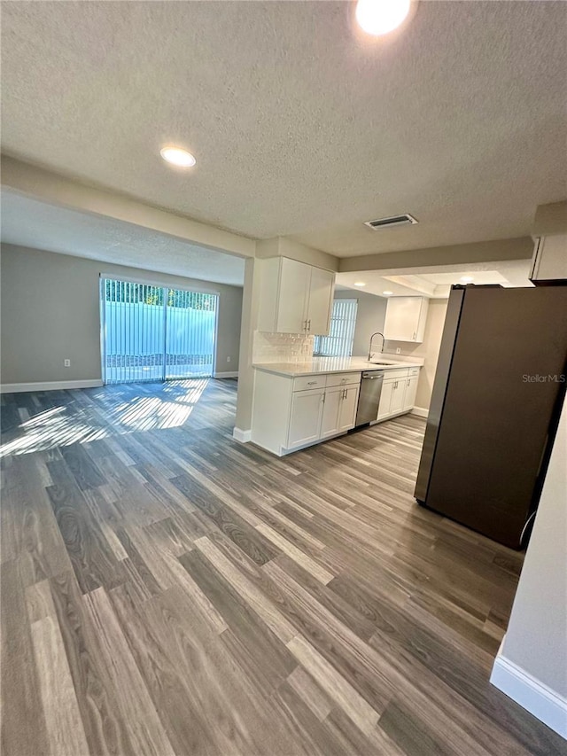 kitchen featuring white cabinets, hardwood / wood-style flooring, a textured ceiling, and appliances with stainless steel finishes