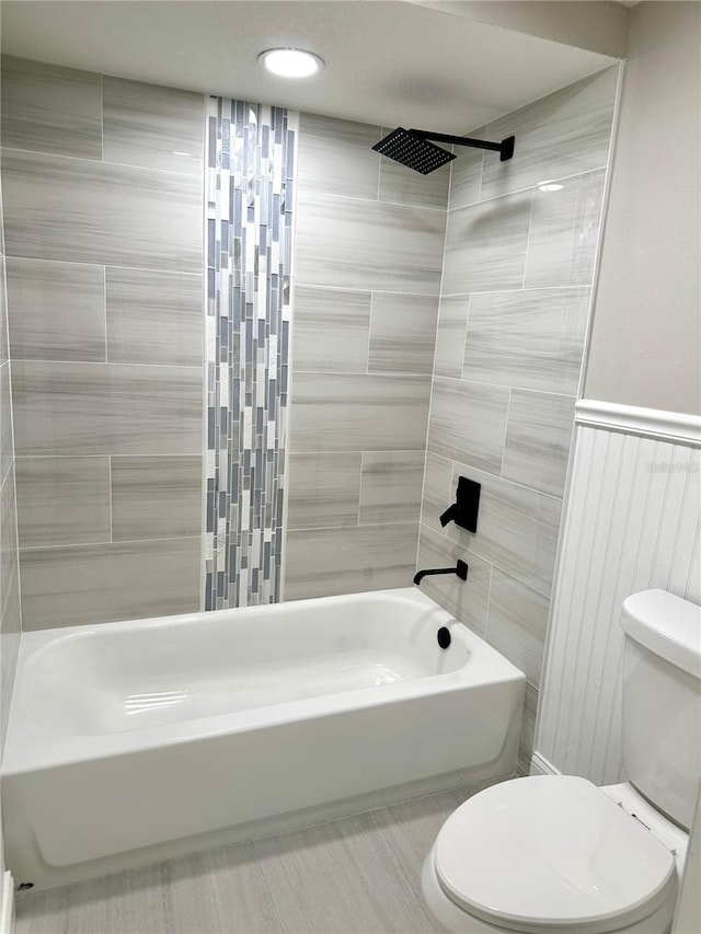 bathroom featuring toilet and tiled shower / bath