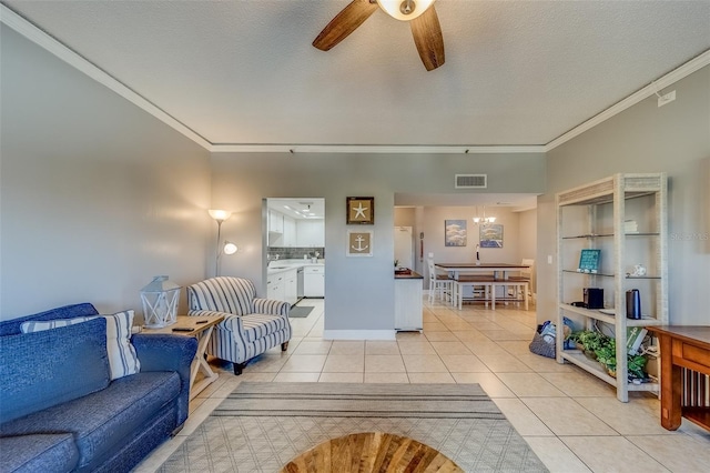 tiled living room with a textured ceiling, ceiling fan, and crown molding