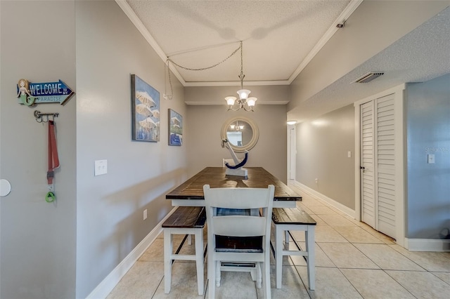 dining room with ornamental molding, a textured ceiling, light tile patterned floors, and an inviting chandelier