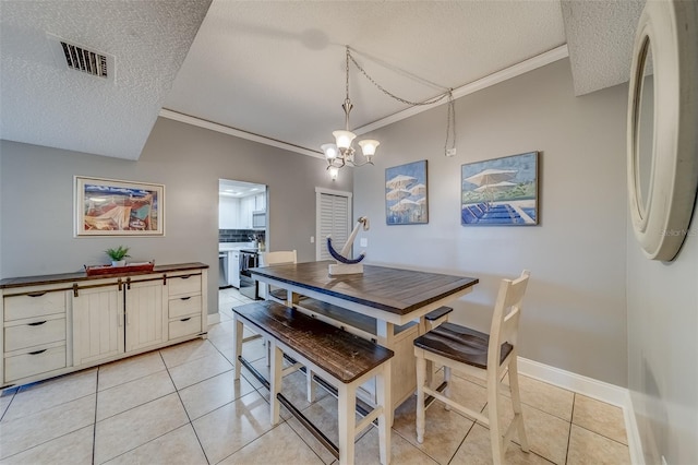 tiled dining room featuring an inviting chandelier, a textured ceiling, and ornamental molding