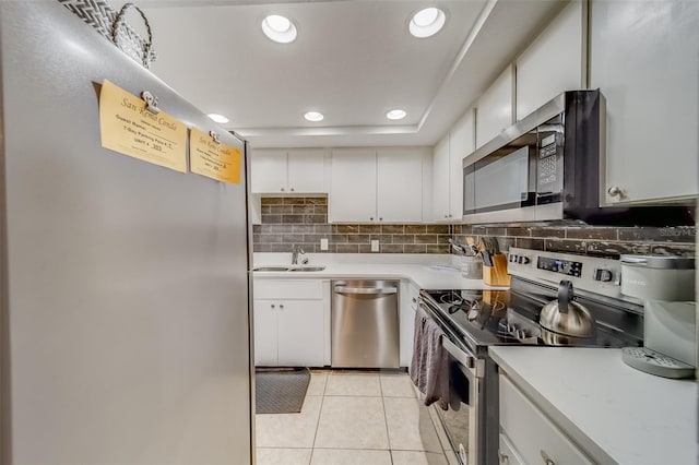 kitchen featuring sink, stainless steel appliances, white cabinetry, and light tile patterned flooring