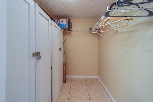 walk in closet with light tile patterned floors