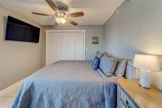 tiled bedroom featuring a textured ceiling, a closet, and ceiling fan