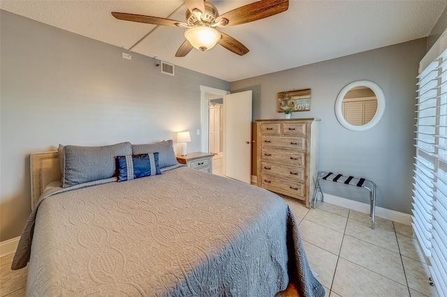 tiled bedroom with ceiling fan and multiple windows