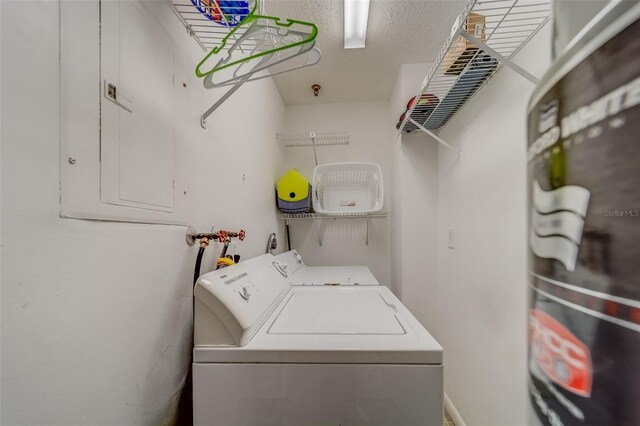 washroom featuring a textured ceiling and washer and clothes dryer