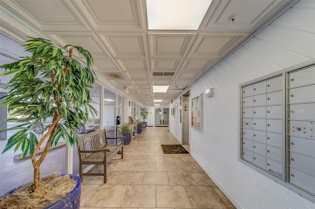 corridor with a mail area and light tile patterned floors