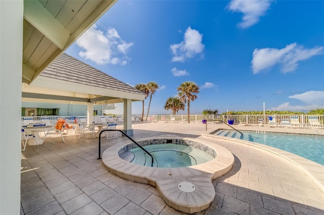 view of swimming pool featuring a community hot tub and a patio