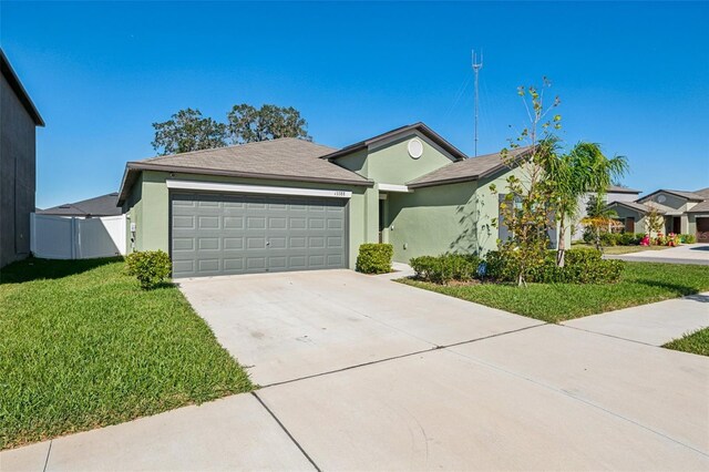 single story home featuring a garage and a front lawn