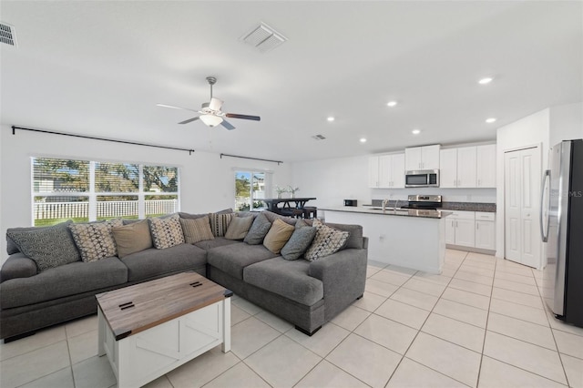 tiled living room featuring ceiling fan and sink