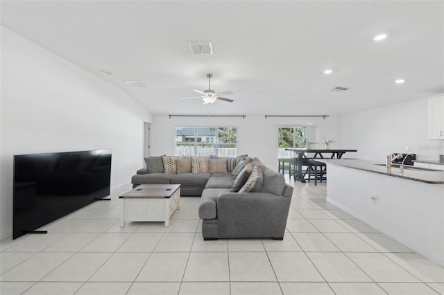 living room featuring light tile patterned floors, ceiling fan, and sink