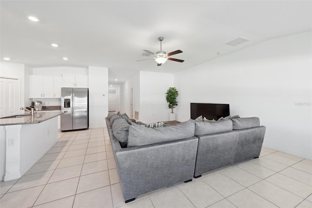 tiled living room featuring ceiling fan and sink