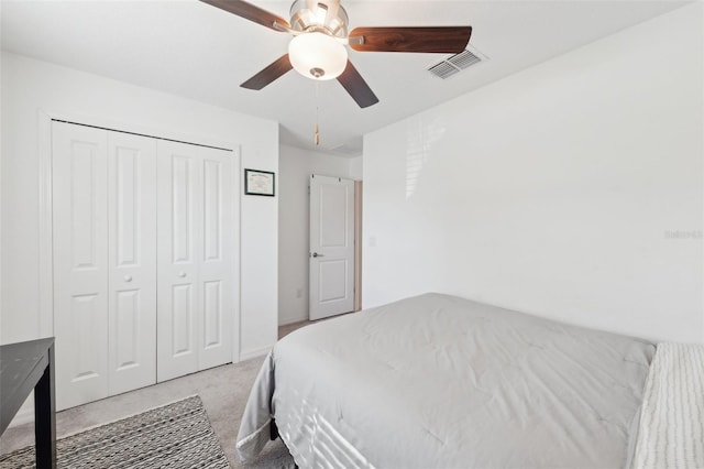 bedroom featuring ceiling fan, a closet, and light carpet