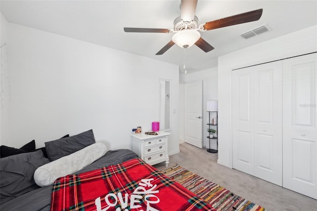 bedroom featuring ceiling fan, light carpet, and a closet