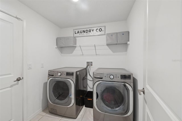 clothes washing area featuring light tile patterned flooring and washing machine and clothes dryer