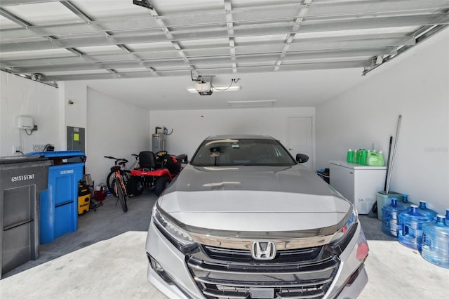 garage with electric panel, water heater, refrigerator, and a garage door opener