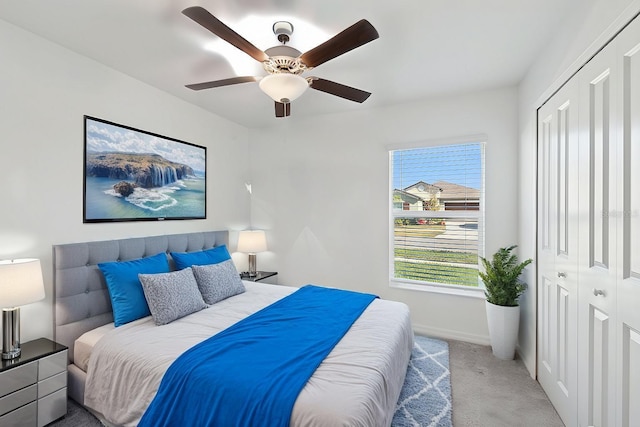 bedroom with baseboards, a closet, a ceiling fan, and light colored carpet