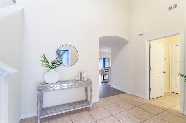 tiled foyer entrance featuring a towering ceiling