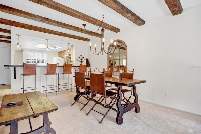 carpeted dining area with beamed ceiling and ceiling fan with notable chandelier