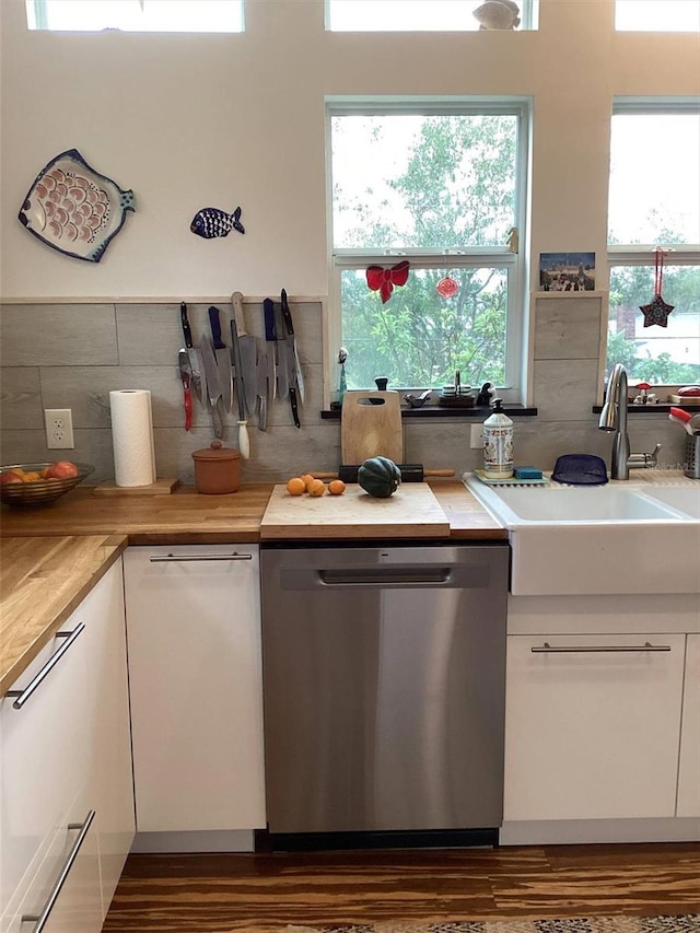 kitchen with dishwasher, white cabinets, wood counters, and sink