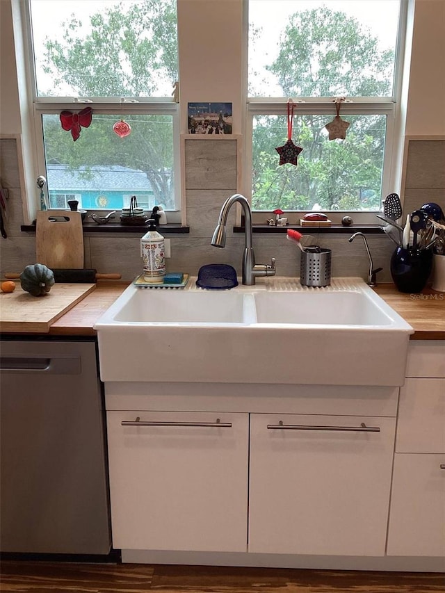 kitchen with dishwasher, white cabinets, and sink