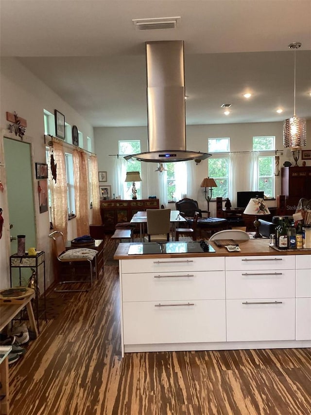 kitchen with white cabinetry, dark hardwood / wood-style flooring, pendant lighting, black electric cooktop, and island range hood