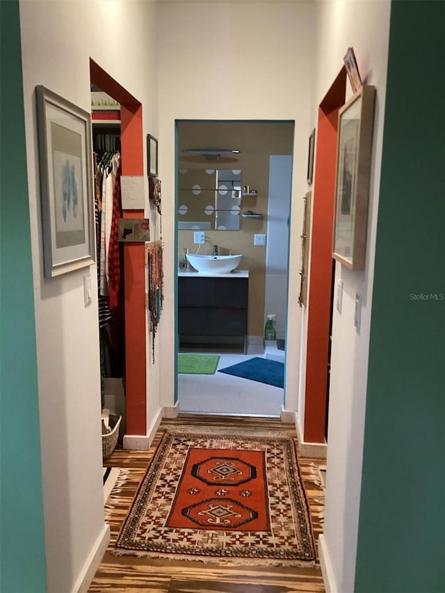 hall with hardwood / wood-style floors and sink