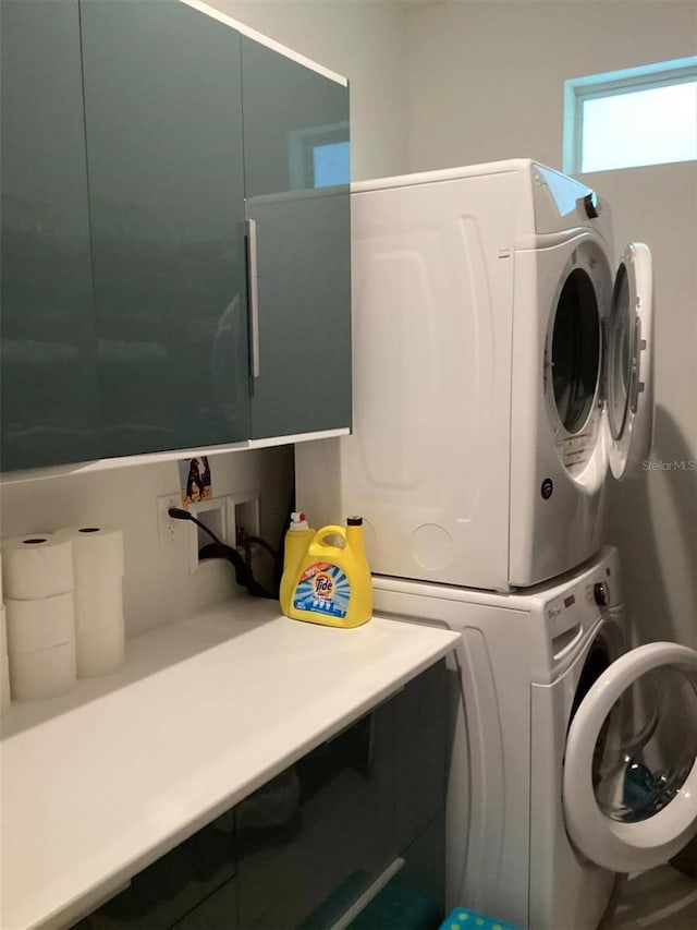 laundry area featuring stacked washer / drying machine