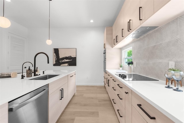 kitchen featuring sink, stainless steel dishwasher, pendant lighting, black electric stovetop, and light wood-type flooring