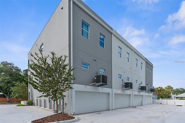 view of building exterior with central AC and a garage