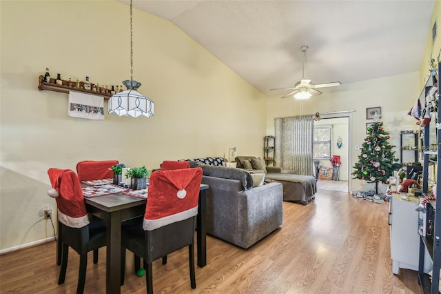 dining area with wood-type flooring, vaulted ceiling, and ceiling fan