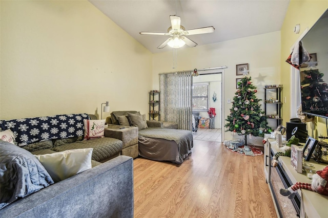 living room featuring ceiling fan, vaulted ceiling, and light wood-type flooring