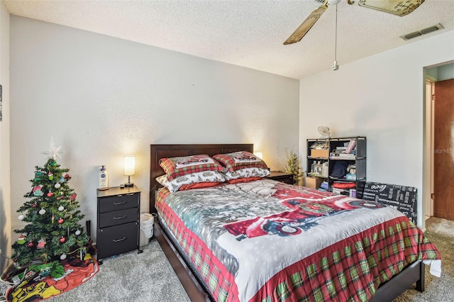 carpeted bedroom featuring a textured ceiling and ceiling fan