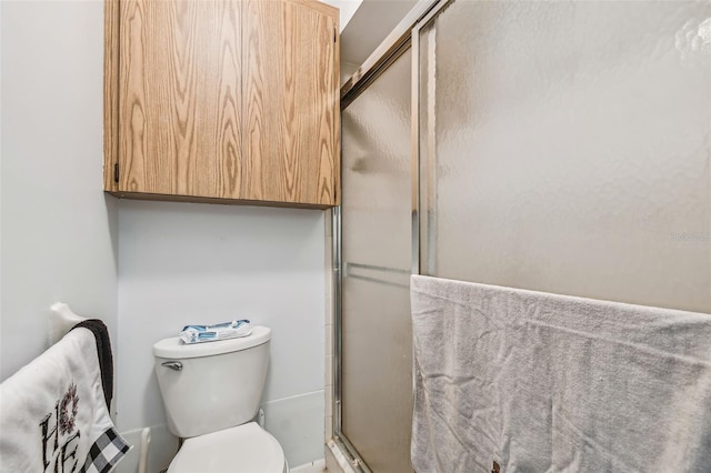 bathroom featuring an enclosed shower and toilet