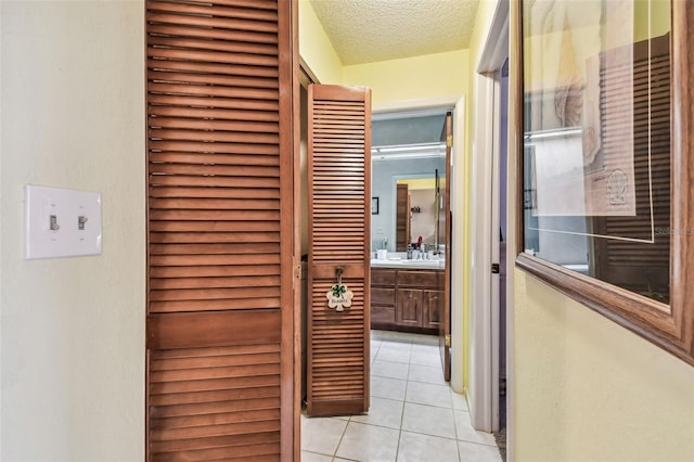 hallway featuring light tile patterned flooring and a textured ceiling