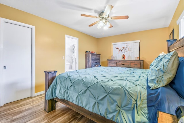 bedroom with connected bathroom, hardwood / wood-style flooring, and ceiling fan