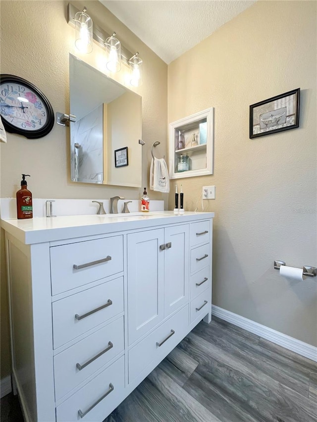 bathroom with a textured ceiling, vanity, and hardwood / wood-style flooring