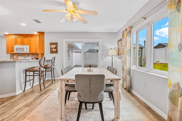 dining area with ceiling fan, plenty of natural light, and light wood-type flooring