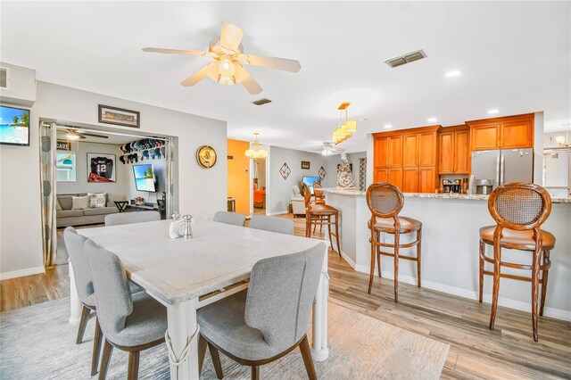 dining area featuring ceiling fan and light wood-type flooring