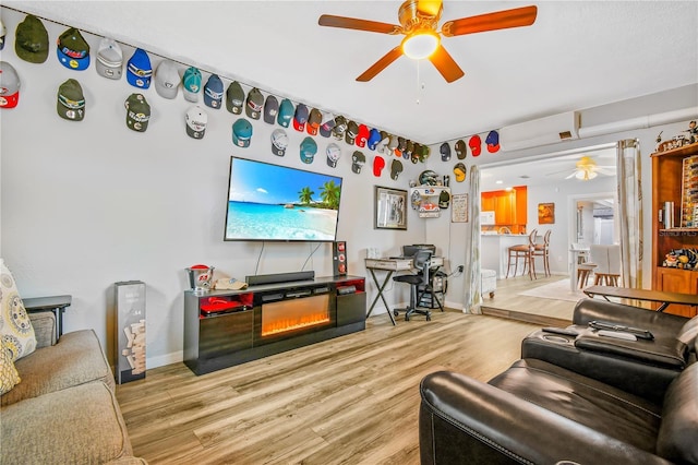 living room with ceiling fan and light hardwood / wood-style flooring