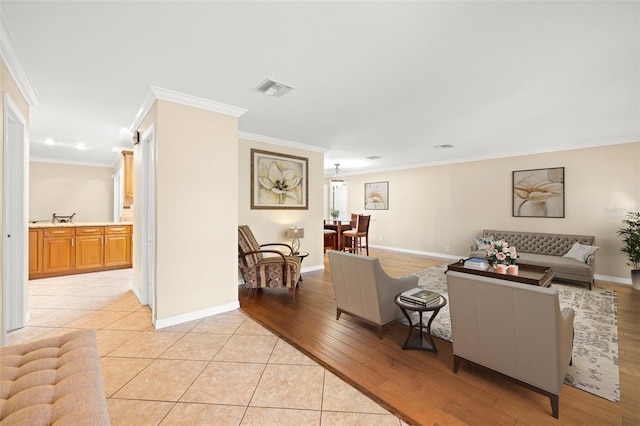 living room with light hardwood / wood-style flooring and crown molding