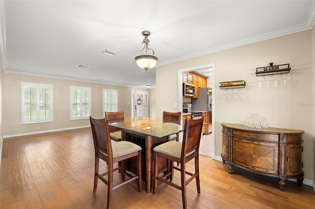 dining room featuring wood-type flooring and ornamental molding