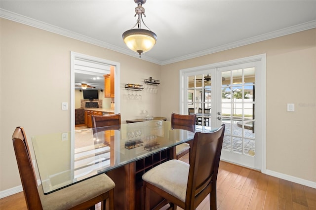 dining area with ceiling fan, wood-type flooring, ornamental molding, and french doors