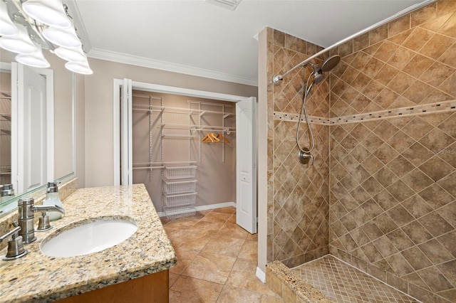 bathroom with tile patterned floors, vanity, ornamental molding, and tiled shower