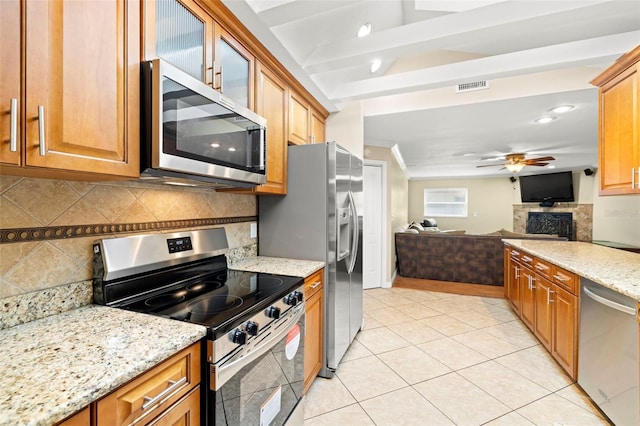 kitchen featuring ceiling fan, light stone countertops, stainless steel appliances, and light tile patterned floors