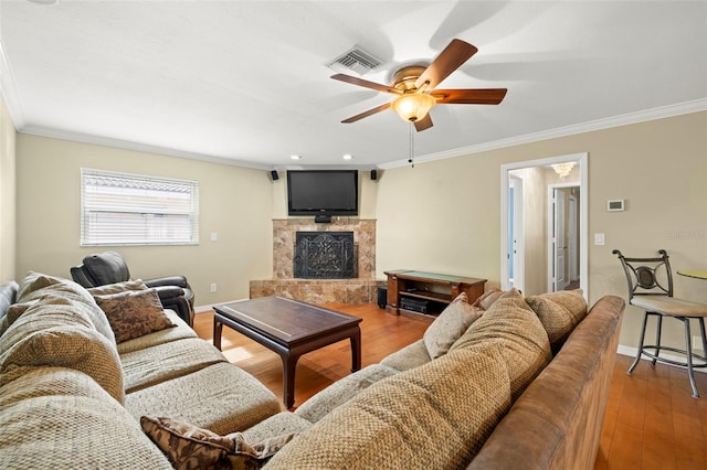 living room with hardwood / wood-style floors, ceiling fan, crown molding, and a high end fireplace