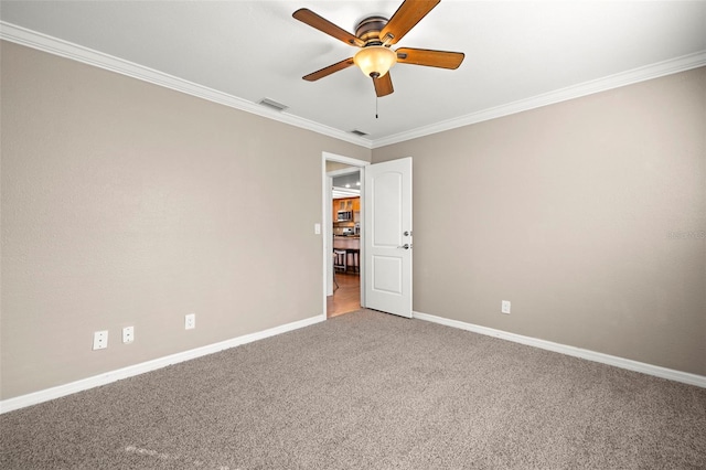 carpeted spare room featuring ceiling fan and crown molding