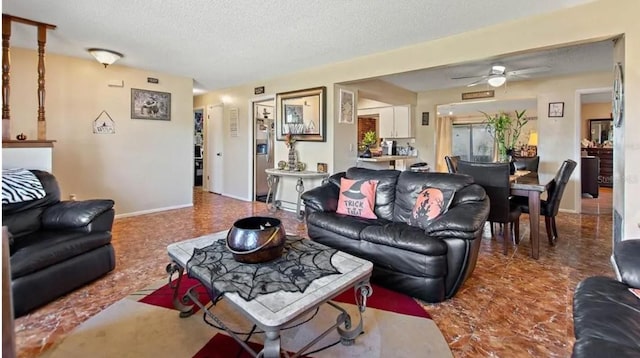 living room with a textured ceiling and ceiling fan