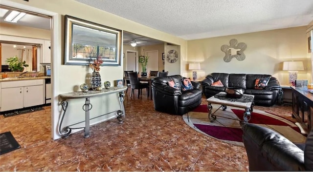 living room featuring ceiling fan, sink, and a textured ceiling