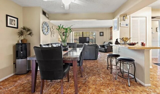 dining room featuring ceiling fan and a textured ceiling